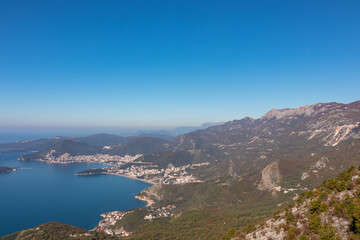 Fototapeta premium Panoramic aerial view on the coastline of Budva and Sveti Nikola Island seen from Goli Vrh, Adriatic Mediterranean Sea, Montenegro, Balkan, Europe. Luxury hotel resorts along Budvanian Riviera.