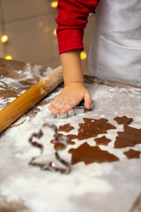 Little boy making Christmas cookies in kitchen, close up view. Vertical photo.