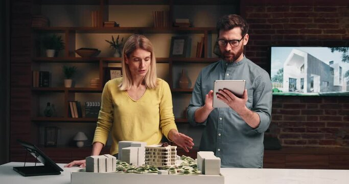 Man and woman architects discussing an architectural project looking at a layout