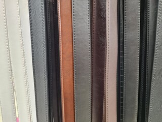 Lots of colorful leather belts hanging in store