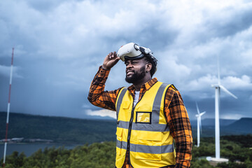 Portrait of engineer African American man working with VR headset in wind turbine farm.