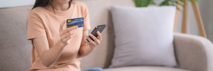 Young asian woman hand using mobile phone and credit card for online payment, electronic wallet.
