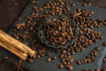 roasted coffee beans with spices, anise and cinnamon sticks in a metal turkish bowl on a black background 4