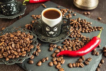 traditional turkish coffee in vintage cup, anise, roasted beans with hot spicy chili pepper on brown background  1
