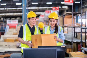 Staff working in large depot storage warehouse trainee check packing box and scan at cashier counter