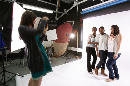 Photo Studio: Group Portrait. A group of 4 ate teenage girls enjoying a photo shoot in a college professional studio. From a series of related images.