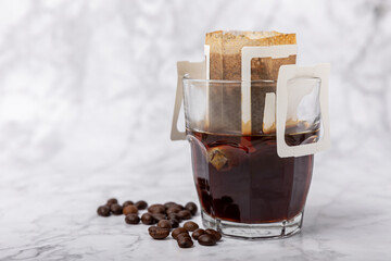 Cup of freshly brewed coffee or coffee sachet filter on the cup. Making drip coffee with a special...