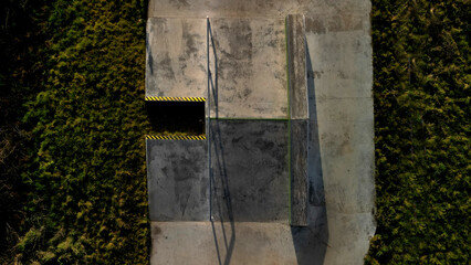 Skateboard park with concrete cement surface with concrete skateboard obstacles is designed for roller sports. Cycling is not allowed except for freestyle bikes.  winter morning sunrise, above, high