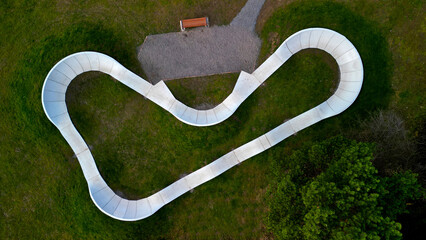 bike path in the car park Pumping (moving up and down) is used instead of pedaling and bouncing to move bicycles, scooters, skateboards and inline skates along the modular pumptrack track