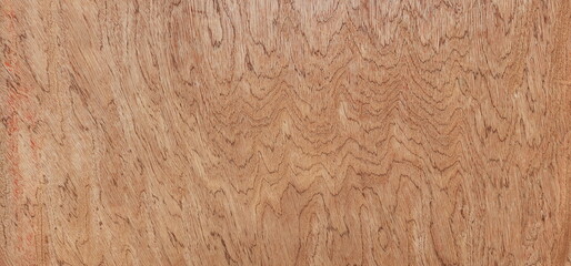 Plywood surface with natural wood pattern. Plywood has a beautiful pattern. Board patterned on brown background.
