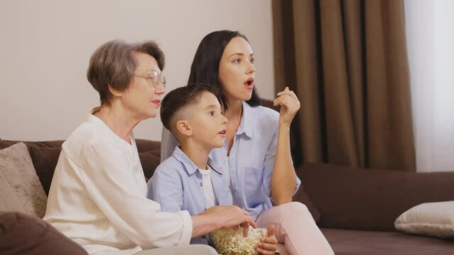 Multigenerational Family Watching A Movie On Sofa And Eating Popcorn, Leisure