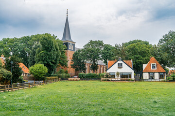 Fototapeta na wymiar Belfry of the St. Bonifatiuskerk church in the village of Cornwerd surrounded by farmland in the province of Friesland, Netherlands