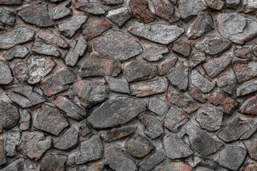 Beautiful rustic textured background stone wall several shades of gray. Landscape structure. Heavy material. Solid, strong, hand built masonry, concrete. 