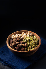 Food Spices concept 3 colors of cardamom pods green, black, white cardamom in wooden cup on black slate stone background with copy space