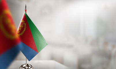 Small flags of the Eritrea on an abstract blurry background