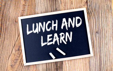 LUNCH AND LEARN text on a chalkboard on the wooden background