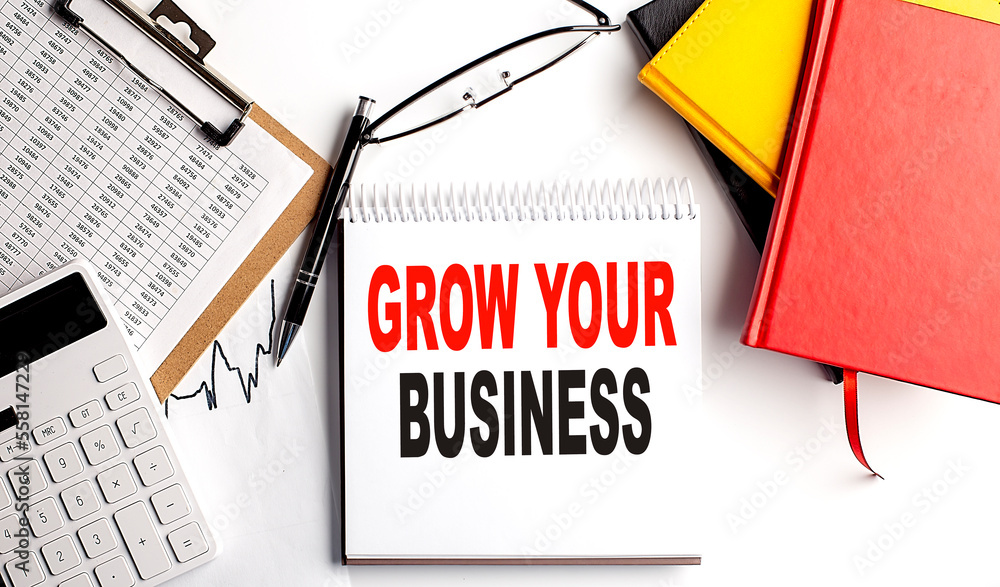 Poster grow your business text on notebook with clipboard and calculator on white background