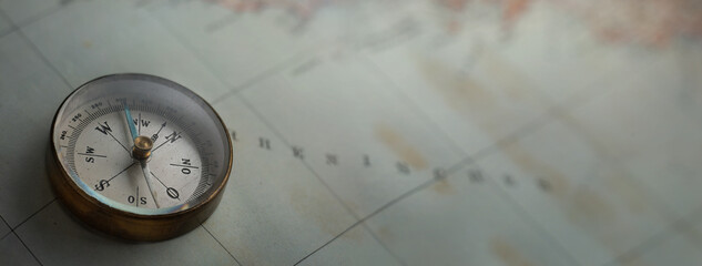 Magnetic old compass on vintage world map. Travel, geography, navigation, tourism and exploration...