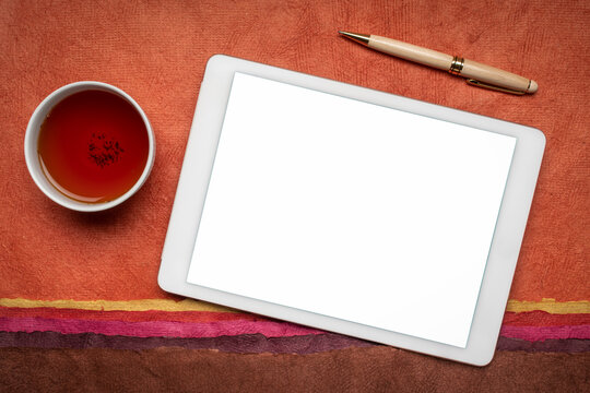 Mockup Of Digital Tablet With A Blank Isolated Screen (clipping Path Included), Flat Lay With A Cup Of Tea Against Abstract Paper Landscape