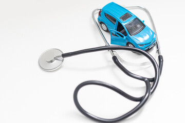 Toy car and stethoscope. Car automotive diagnostic, inspection, repair and maintenance concept.
