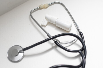 Coronavirus concept. Nasal seawater spray, stethoscope and viruses on a white background.