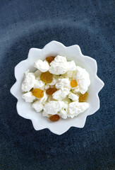 Fresh large cottage cheese with raisins in a white plate