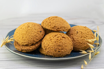 Oatmeal cookies in a plate on a wooden background