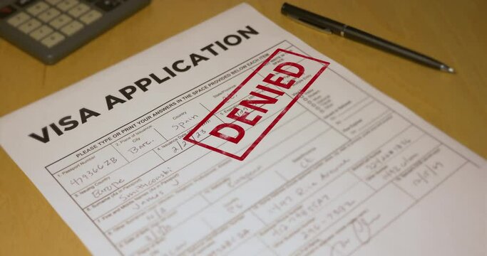 A closeup view of an VISA application getting denied. Data on form is fictional.  	