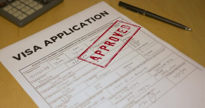 A closeup view of an VISA application getting approved. Data on form is fictional.  	