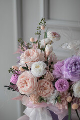 Beautiful composition with peonies and roses in a purpl box on pink chair. Bouquet of tenders peonies a girl for mother's day, valentine's day, Woman's day 8 march.