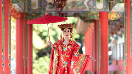 Obraz na płótnie Canvas portrait of a woman. person in traditional costume. woman in traditional costume. Beautiful young woman in a bright red dress and a crown of Chinese Queen posing 