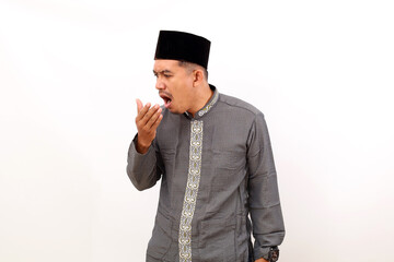 Obraz na płótnie Canvas Asian muslim man smelling his breath gesture. Isolated on white background