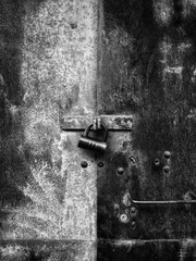 Black and white padlock on old rusty door. Metal garage doors with copy space.
