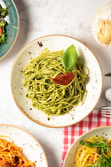 View from above of various Italian food dishes, especially pasta with pesto. High quality photo