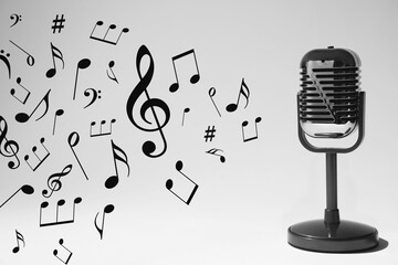 Music notes and other musical symbols flowing from retro microphone on light background