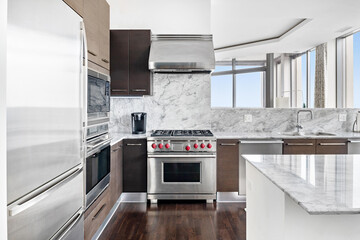 Modern Kitchen with Stainless Steel Luxury Appliances. Contemporary wood tone cabinets with white marble backsplash.