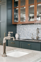 Transitional Kitchen with Stainless Steel Faucet. Glass front dual tone cabinets with patterned...