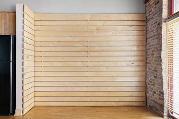 Empty Oak Slat Accent Wall. Vacant living room for virtual staging. Wood and brick accents in...