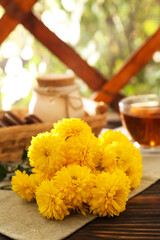 Obraz na płótnie Canvas Beautiful yellow chrysanthemum flowers on wooden table