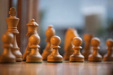 Wooden white chess pieces on a board