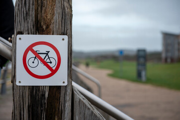 Public sign no cyclists allowed on wooden post outdoors 