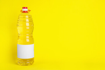 Bottle of cooking oil on yellow background. Space for text