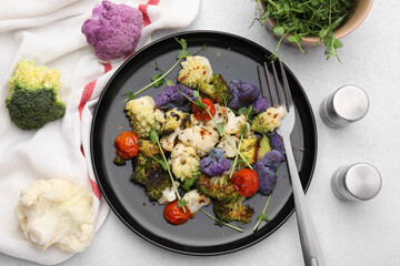 Delicious salad with cauliflower and tomato served on white table, flat lay