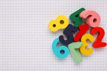 Colorful numbers on sheet of grid paper, flat lay. Space for text