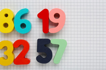 Colorful numbers on sheet of grid paper, flat lay. Space for text