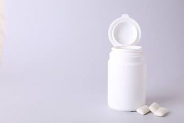 Jar with chewing gums on light grey background. Space for text