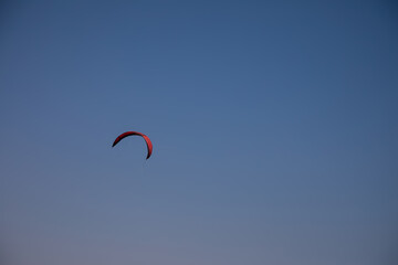 Red kite on blue sky. Nice parachute. Colorful sky. Sunny summer day. Wind in the sky.