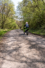 A man driving a motorbike on the driveway in the park.