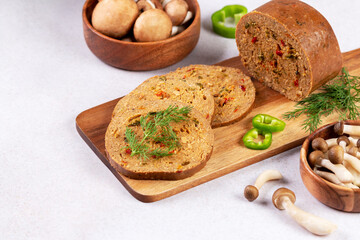 Mushroom based vegan sausage with vegetables and spices on wooden board, top view