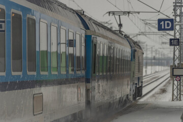 Passenger train near stop in Veseli nad Luznici with snowy platforms